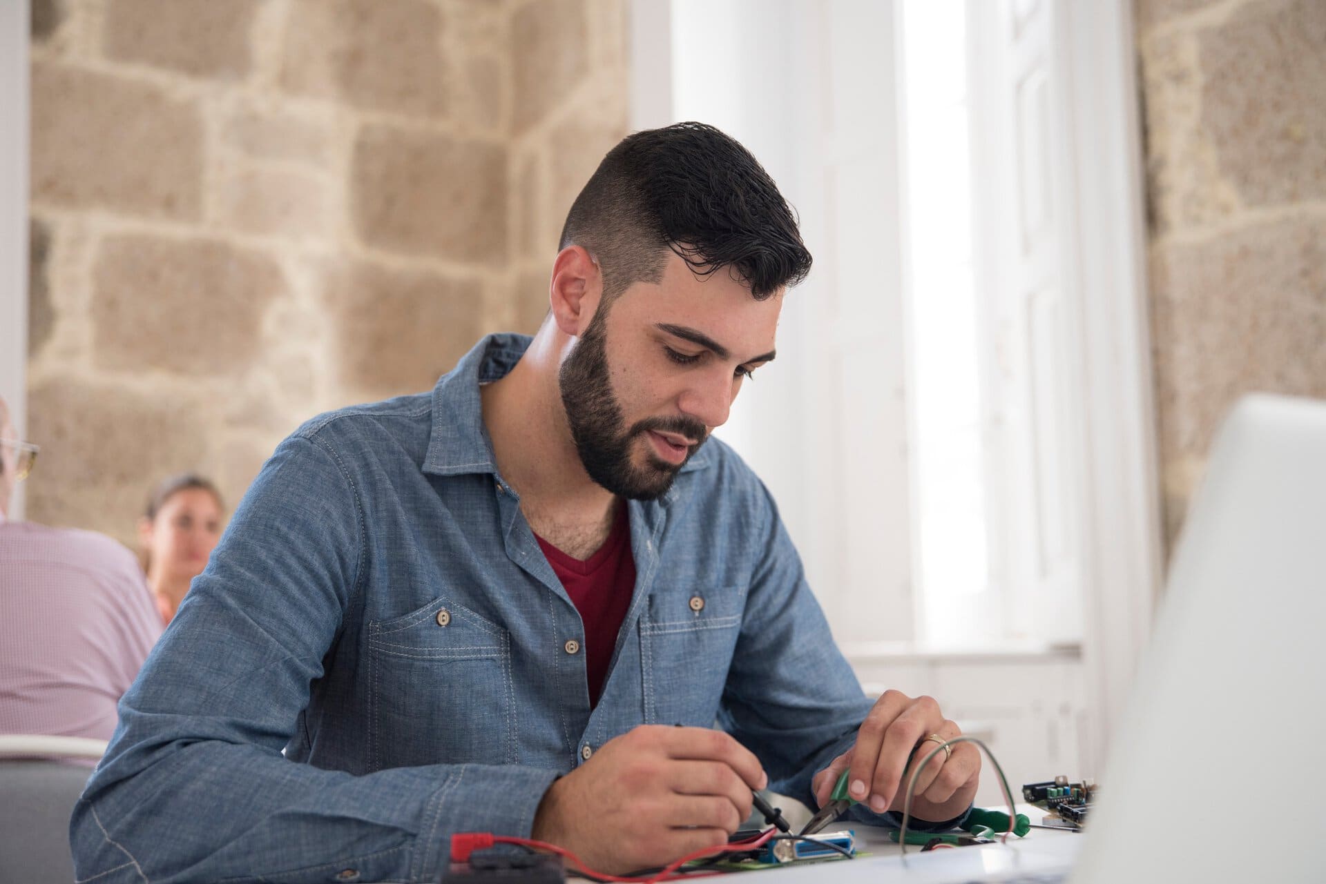Joven técnico reparando un equipo electrónico